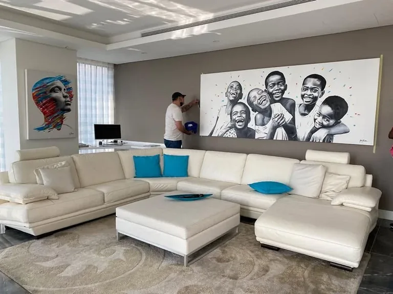 Large paintings displayed above a sofa in a living room